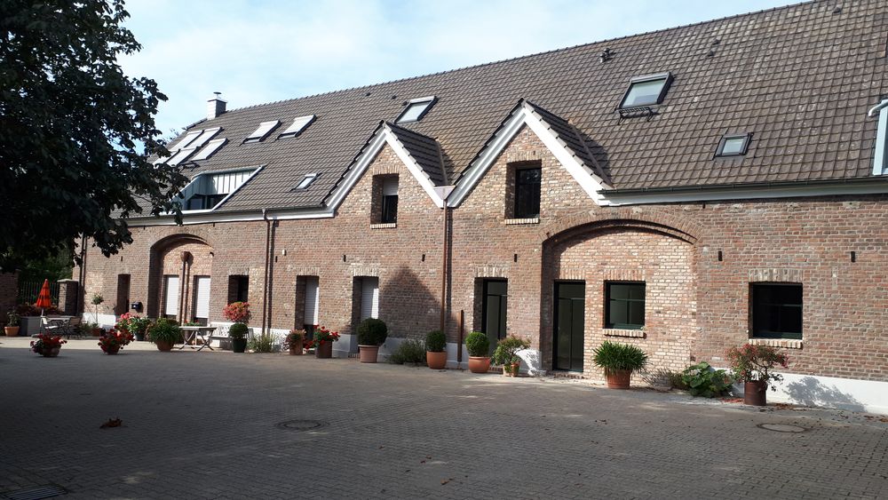 Umgenutztes landwirtschaftliches Backsteingebäude mit Gauben, saniert zum Mehrfamilienhaus im Effizienzhaus-55-Standard